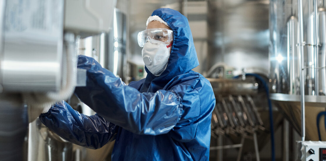 homem trabalhando com roupa protetora e equipamentos de proteção em uma fábrica