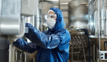 homem trabalhando com roupa protetora e equipamentos de proteção em uma fábrica